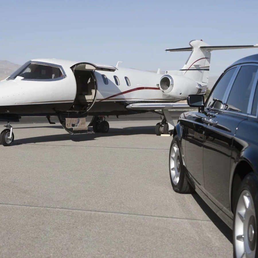Private jet and luxury car on tarmac.