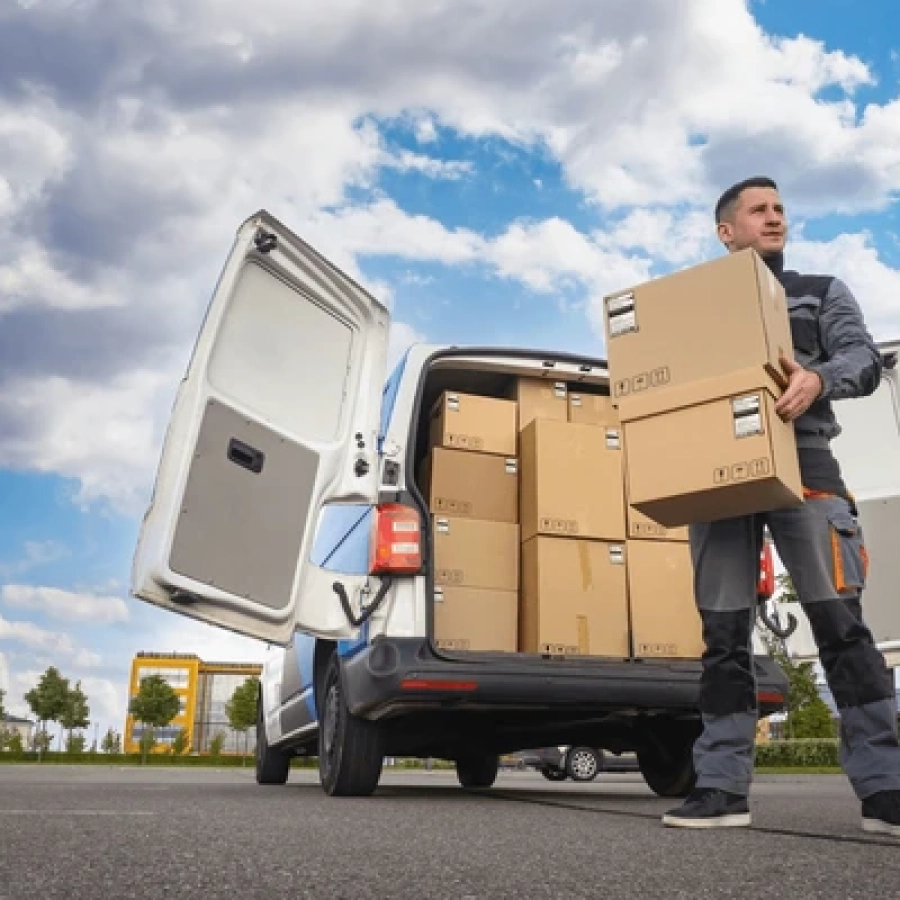 Delivery person unloading boxes from van.